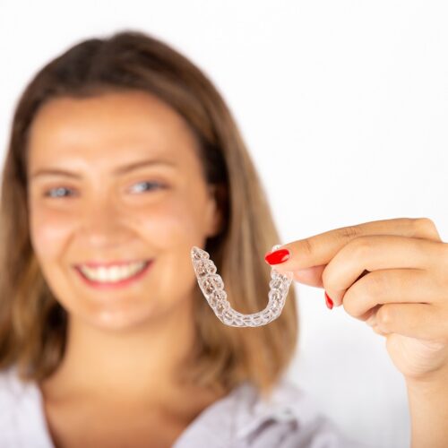 Beautiful smiling young woman with aligner.
